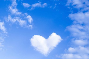 Mavi gökyüzünde kalp şeklinde bulut ve metin alanı