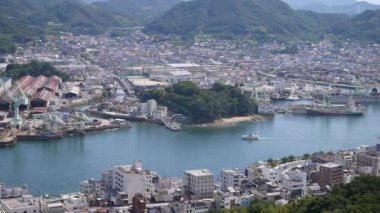 Güneşli bir günde Hiroşima 'nın Onomichi şehrinde yavaşça ilerleyen bir feribot manzarası..