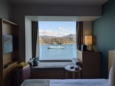 Güzel deniz, gökyüzü ve kargo gemisi odanın içinden ve penceresinden görüldü.