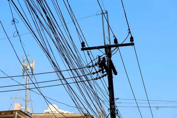 stock image Tangled electrical wires on urban electric pole. Disorganized and messy to organization management concept. Closeup tangled electrical wires . Should take underground wire for beautiful landscape.