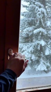 Sabah karla kaplı ormana bakmak için ahşap bir pencere açıyorum. Pencere görünümü