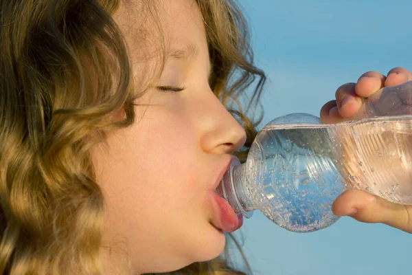 Girl drinks mineral water from PET bottle