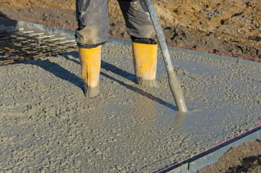 Beton, beton vibratörlü inşaatçı tarafından sıkıştırılır.