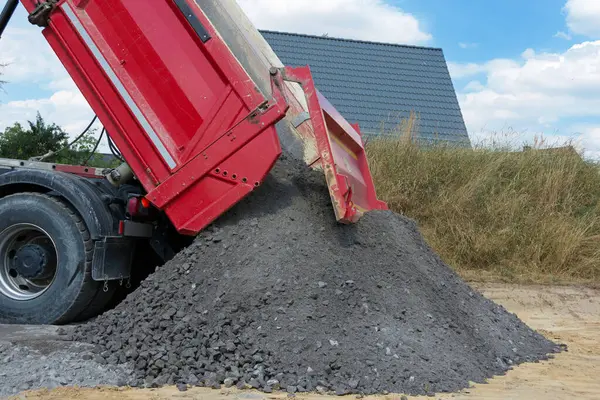 4 eksenli kamyon, doğal taştan yapılmış 0-44 mm 'lik çakılları devirirken