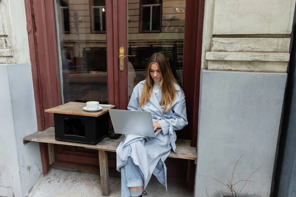 Joven Freelancer Gabardina Azul Usando Laptop Mientras Está Sentado Lado — Foto de Stock