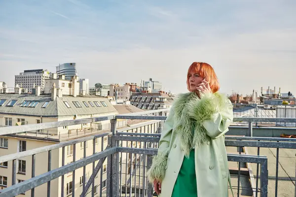 stock image alluring woman in stylish casual attire talking on mobile phone on roof terrace in Vienna, Austria