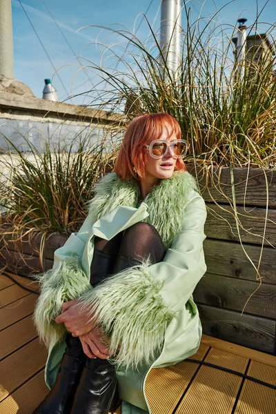 stock image female traveler in trendy sunglasses sitting and looking away on roof terrace in Vienna, Austria