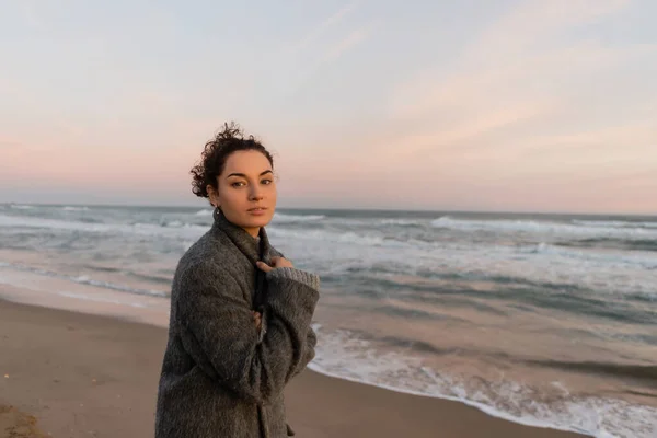 Junge Frau blickt am Strand von Barcelona in die Kamera — Stockfoto