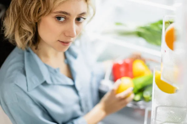 High angle view of young woman standing near opened refrigerator — Stock Photo