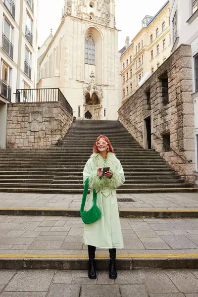 Міські вібрації, щаслива жінка в модних сонцезахисних окулярах з смартфоном, що йде по міській вулиці у Відні — стокове фото