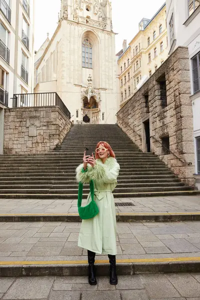 Стиль жизни в путешествиях, улыбающаяся женщина в модных солнцезащитных очках, фотографирующаяся на смартфоне в Вене, Австрия — стоковое фото