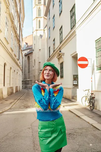 Street fashion, amazed woman in beret and trendy clothes looking away on city street in Vienna — Stock Photo