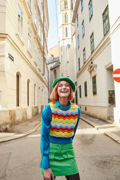Overjoyed woman in beret and trendy clothes laughing at camera on city street in Vienna, Austria — Stock Photo