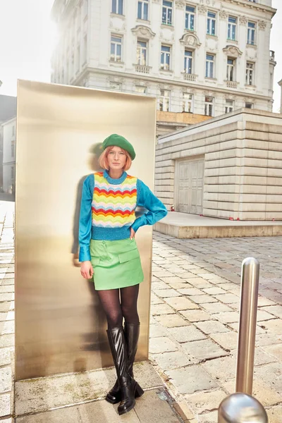Modern street fashion, trendy woman in beret and colorful vest posing on street in Vienna, Austria — Stock Photo