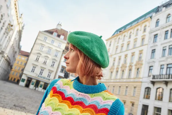 Mode de rue moderne, femme élégante en béret et gilet lumineux regardant loin dans la rue à Vienne — Photo de stock