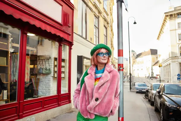 Mulher elegante em casaco de pele falso e óculos de sol olhando para longe na rua urbana em Viena, Áustria — Fotografia de Stock