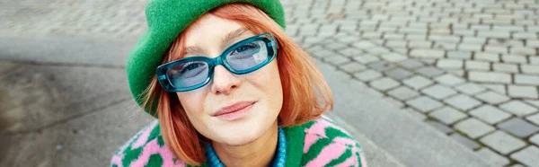 Portrait of stylish woman in animal print sweater and sunglasses looking at camera on street, banner — Stock Photo
