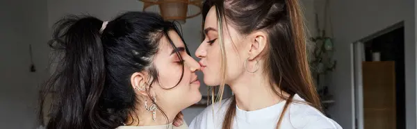 Bannière horizontale de jeune femme embrassant nez de petite amie heureuse dans la cuisine, couple lgbt — Photo de stock