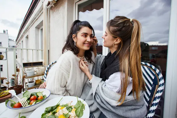 Momento íntimo y feliz de amar pareja lesbiana desayunando en balcón, concepto lgbt - foto de stock