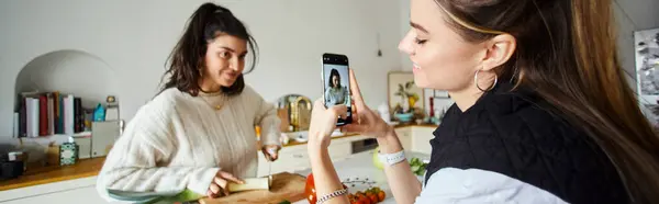 Heureuse jeune femme lesbienne prendre des photos sur smartphone de sa petite amie faire de la salade, bannière — Photo de stock