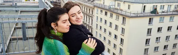 Banner of lesbian couple in casual attire looking at city on rooftop, moment of love and connection — Stock Photo