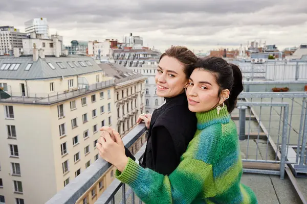 Young lgbt couple in casual attire looking at city on rooftop, a moment of love and connection — Stock Photo