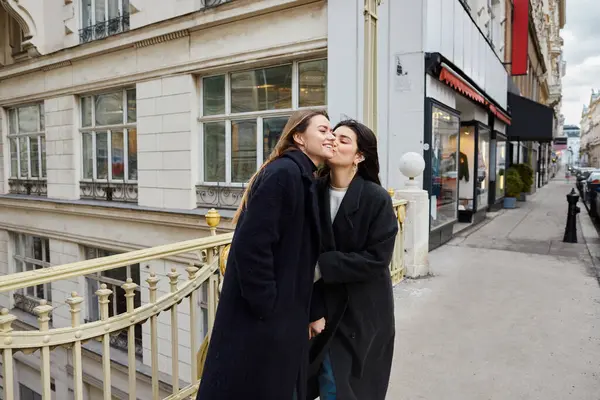 Intimate moment of happy lesbian women in love standing together on street in European city — Stock Photo