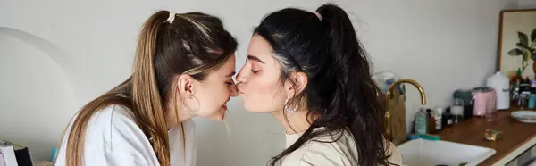 Happy moment of lesbian couple, young woman kissing nose of her girlfriend in kitchen, banner — Stock Photo