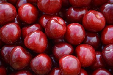 Sıkıca paketlenmiş olgun kirazlar, mat cilt ve doğal kusurlarla besin gerçekçiliği, otantik meyve betimlemesi ve organik üretim temsilciliği için yakın ayrıntıda yakalandı.