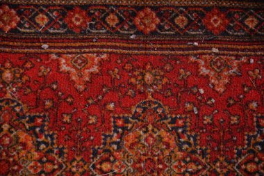 Kırmızı desenli doğu halısı tekstili. Simetrik çiçek süslemeleri ve klasik desenli zengin bir kırmızı doğu halısının yakın çekimi..