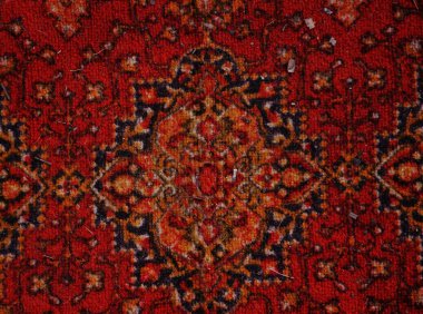 Kırmızı desenli doğu halısı tekstili. Simetrik çiçek süslemeleri ve klasik desenli zengin bir kırmızı doğu halısının yakın çekimi..