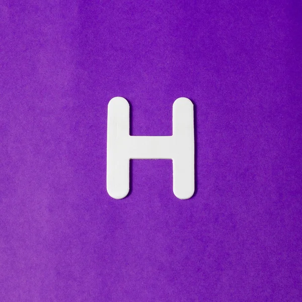 大文字H 木のテクスチャ 紫の背景 — ストック写真