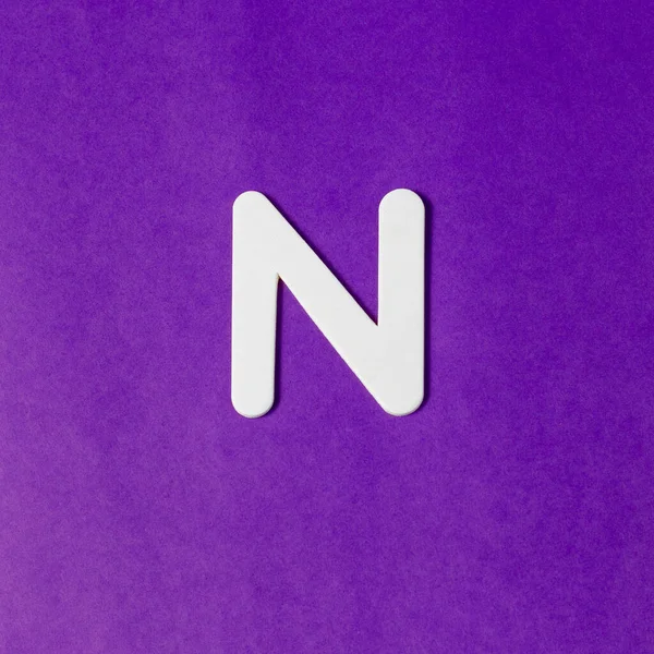 大文字N 木の質感 紫の背景 — ストック写真