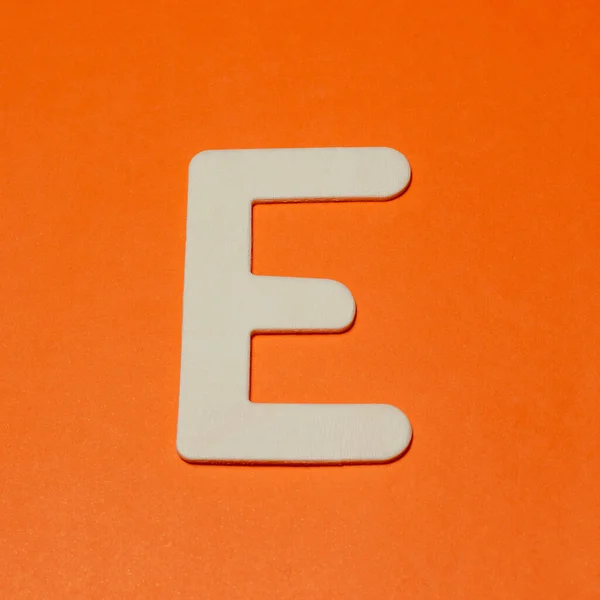 大文字E 木の質感 オレンジの背景 — ストック写真