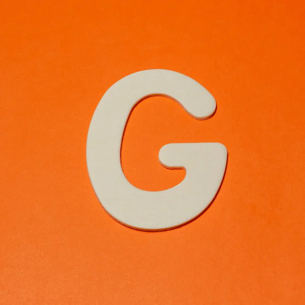 大文字G 木の質感 オレンジの背景 — ストック写真