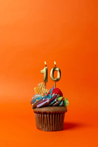 stock image birthday cake with number - cupcake on orange background with birthday candles