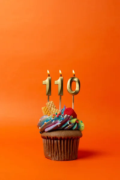 stock image birthday cake with number 110 - cupcake on orange background with birthday candles