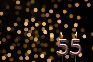 Odaklanamayan ışıklarla arka planı gösteren güzel bir görüntü bir bokeh etkisi yaratarak neşeli ve neşeli bir atmosfer yaratıyor. Bir köşede, iki tane yanan doğum günü mumu biraz sıcaklık ve kutlama katar, özel bir şeyi temsil etmek için mükemmeldir.