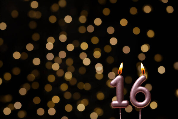 Красивое изображение, демонстрирующее фон с нефокусированными огнями, создавая эффект боке, создавая радостную и праздничную атмосферу. В одном углу две зажженные свечи в честь дня рождения добавляют немного тепла и торжества, идеально подходящие для представления особых эмоций.