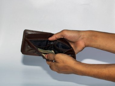 jakarta, Endonezya - 08 Kasım 2022: Bir adamın eli beyaz arka planda izole edilmiş cüzdandan para alır ve gösterir, rupiah Endonezya 'nın para birimidir.