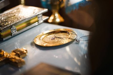 Kilisede, yeni kutsanmış bir haç altın bir tepside yatıyor. İnancın ve dinin sembolleri..