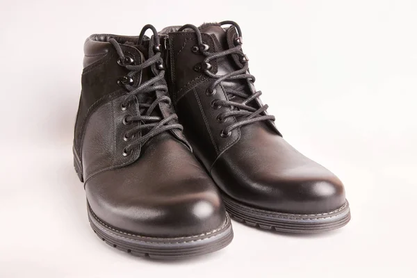 Black leather men\'s boots on a white background. Warm shoes for winter.