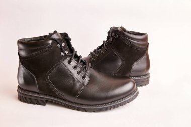 Beyaz arka planda siyah deri erkek çizmeleri. Kış için sıcak ayakkabılar..