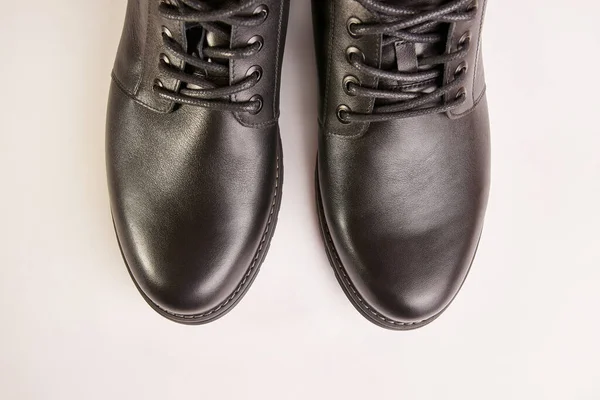 Black leather men\'s boots on a white background. Warm shoes for winter.