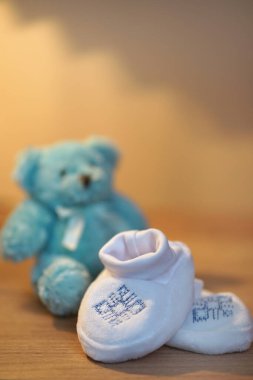 Yeni doğmuş bir bebek ve deniz feneri oyuncağı için nakışlı şenlikli ayakkabılar..