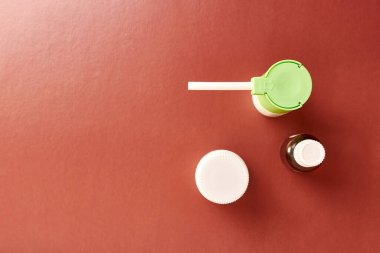 Throat spray and liquid medicine on brown background. Treatment and prevention of diseases.