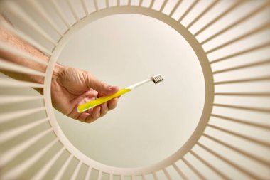 The toothbrush is thrown away for disposal and recycling in the trash. View from below. The concept of disposal and recycling of waste.