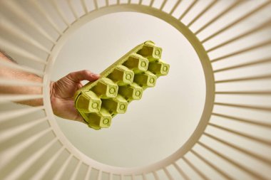 Egg cartons are disposed of and recycled into the trash. View from below. The concept of disposal and recycling of waste.