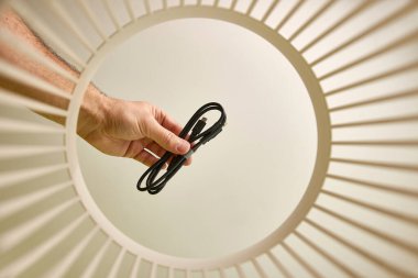 The USB cable is thrown into the trash for disposal and recycling. View from below. The concept of utilization and processing of waste.