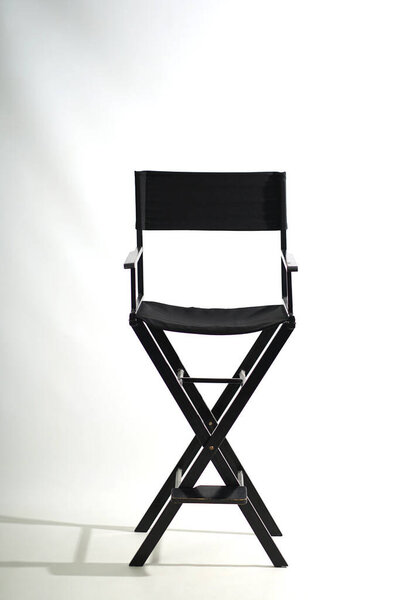                  Черный деревянный раскладной стул на белом фоне.              